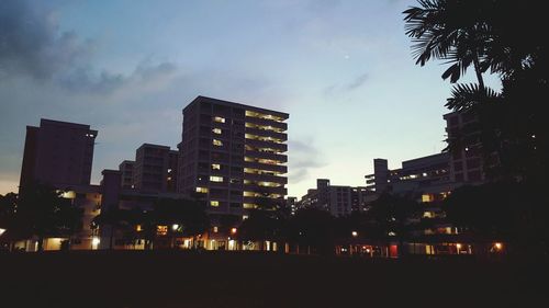 Buildings in city against cloudy sky