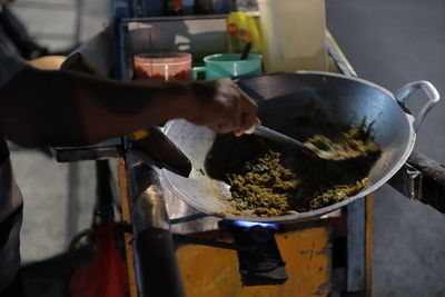 Cropped hands of person preparing food in kitchen