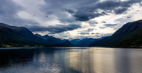 Scenic view of lake by mountains against sky