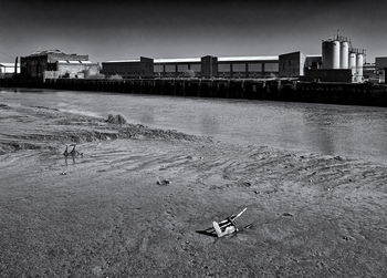 Abandoned building by sea against sky in city