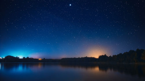 Scenic view of lake against sky at night