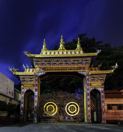 Facade of temple against blue sky at night