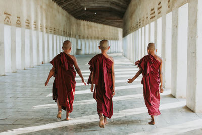 Rear view of women walking in corridor of building