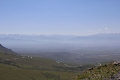 Scenic view of landscape and mountains against blue sky