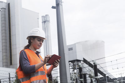 Female worker using tablet at power plant