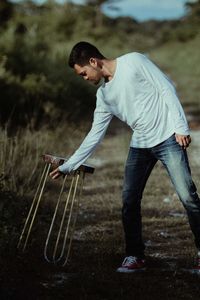 Side view of young man looking away on field