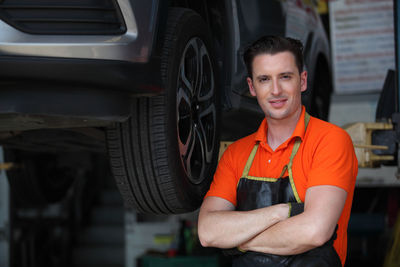 Portrait of smiling man standing by car