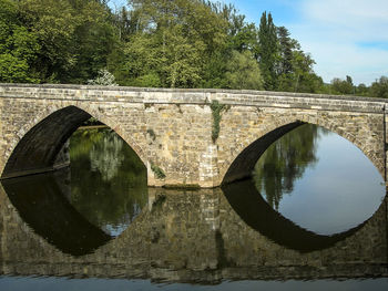 Arch bridge over river against sky