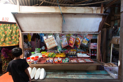 Rear view of man for sale at market stall