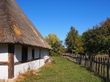 Scenic view of trees and houses against clear blue sky