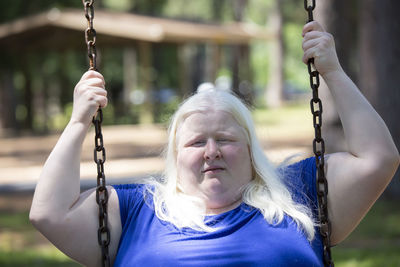 Portrait of woman on swing at playground
