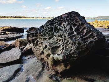 Close-up of rocks on beach against sky