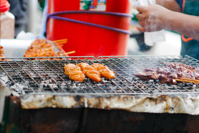 Person preparing food on barbecue grill