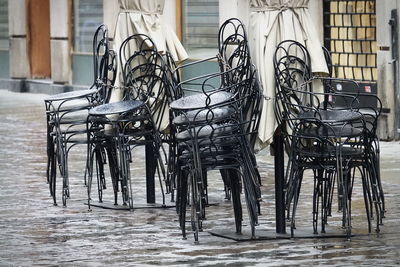 Empty chairs and table against building