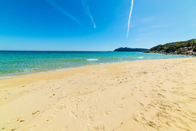 Scenic view of beach against blue sky