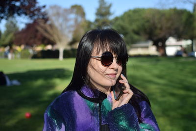 Portrait of young woman wearing sunglasses standing outdoors