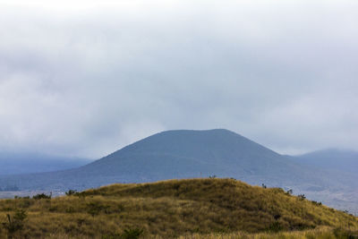 Scenic view of field and mountains against sky