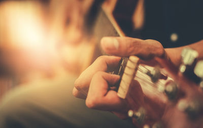 Midsection of man playing guitar