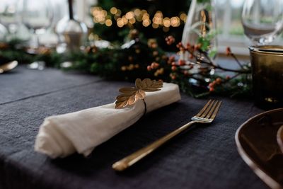Gold napkin holder on a decorated dinner table with candles
