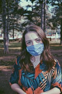 Portrait of young woman against trees