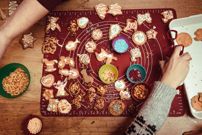 Cropped hands of people preparing cookies on table during christmas