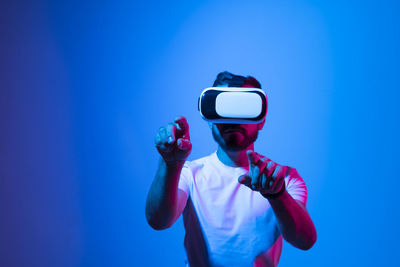 Man photographing against blue background