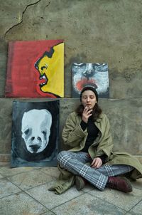 Portrait of a smiling young woman sitting on floor