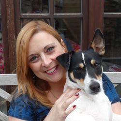 Portrait of smiling woman with dog against glass window