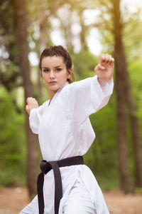 Portrait of young woman standing in park