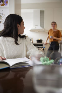 Girl doing homework at dining table