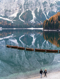 Rear view of people on lake against mountain