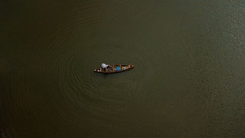 High angle view of man sitting on boat in lake