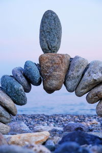 Stack of pebbles on beach against sky