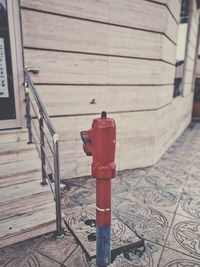 Red fire hydrant on footpath by building