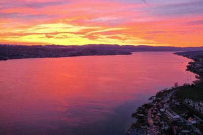 Scenic view of sea against dramatic sky during sunset