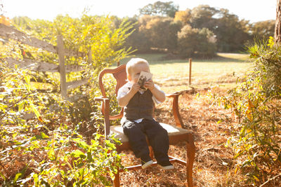 Boy sitting on chair at park