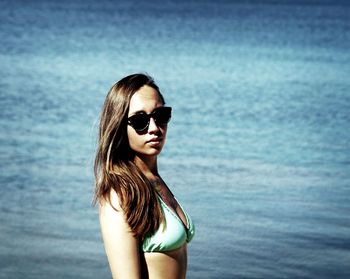 Portrait of young woman wearing sunglasses against sea