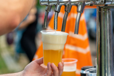 Cropped image of hand holding beer glass