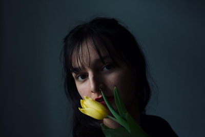 Portrait of woman holding tulip