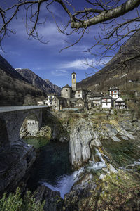 Scenic view of buildings by mountains against sky