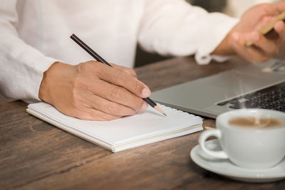 Close-up of man working in plate on table