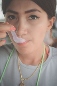 Close-up portrait of young woman drinking soup