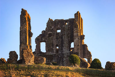 Low angle view of old building against clear blue sky