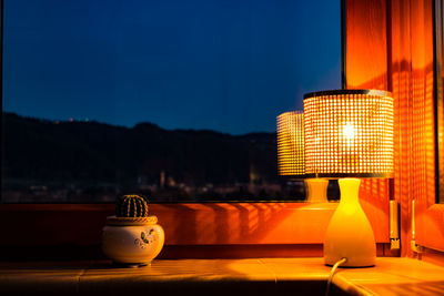 Close-up of illuminated lamp on table