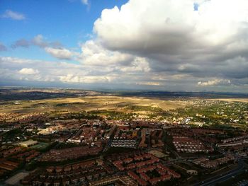 Aerial view of city against cloudy sky