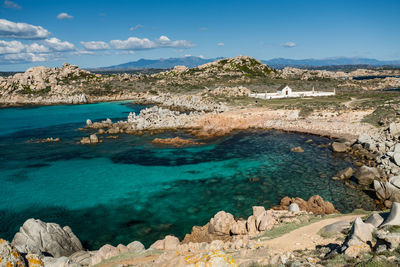 Scenic view of sea and mountains against blue sky