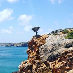 Rock formations by sea against sky