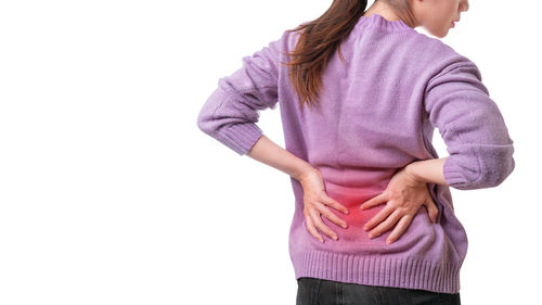 Midsection of woman touching purple against white background