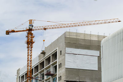 Low angle view of crane against sky