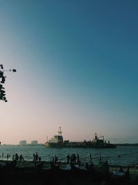 Silhouette boats moored in sea against clear sky